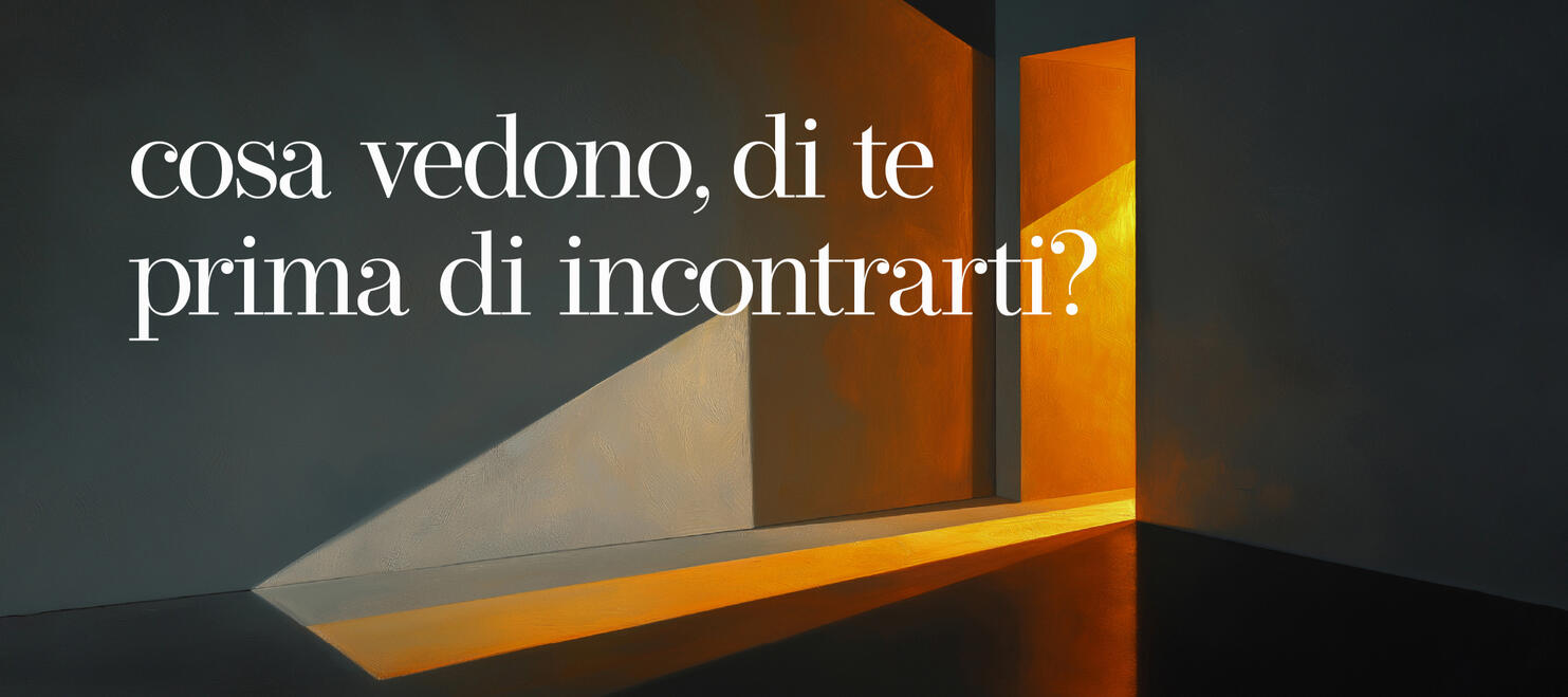 Una scena pittorica di un interno con una porta socchiusa da cui filtra una luce calda e ambrata in una stanza dai toni scuri e freddi, proiettando un'ombra diagonale netta sulla parete. Il testo recita: "cosa vedono, di te, prima di incontrarti?"